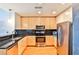 Modern kitchen boasts stainless steel appliances, wood cabinets, and black tiled backsplash at 860 Peachtree Ne St # 2506, Atlanta, GA 30308