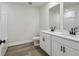 Modern bathroom featuring dual vanities, white cabinets, and wood-look vinyl flooring at 261 Martin Spring Rd, Lawrenceville, GA 30045
