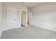 Empty, carpeted bedroom with white doors, trim, and neutral colored walls at 261 Martin Spring Rd, Lawrenceville, GA 30045