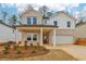 Charming two-story home with a combination brick and siding facade, covered porch, and manicured front yard at 261 Martin Spring Rd, Lawrenceville, GA 30045