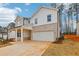 New construction featuring a two-car garage, a mix of brick and vertical siding, and professionally landscaped grounds at 261 Martin Spring Rd, Lawrenceville, GA 30045
