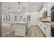 Bright kitchen features an island with pendant lighting, stainless steel appliances and a view to the living room at 261 Martin Spring Rd, Lawrenceville, GA 30045