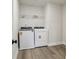 Well-lit laundry room featuring a modern washer and dryer set with vinyl plank flooring at 261 Martin Spring Rd, Lawrenceville, GA 30045