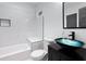 Modern bathroom with a vanity with a unique glass bowl sink, soaking tub, and tiled walls at 883 Gaston Sw St, Atlanta, GA 30310