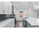 Modern kitchen with white cabinets, quartz countertops, and dark tile backsplash at 883 Gaston Sw St, Atlanta, GA 30310