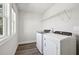 Well-lit laundry room with washer, dryer, and wire rack shelf for added storage and organization at 281 Martin Spring Rd, Lawrenceville, GA 30045