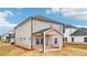The backyard of a modern two-story home with a covered patio and brick foundation at 711 Lily Blossom Path, Lawrenceville, GA 30045