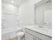 Bright bathroom with white cabinets, large mirror, shower and tub combo at 711 Lily Blossom Path, Lawrenceville, GA 30045