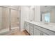 Bright bathroom featuring a spacious glass-enclosed shower and double sink vanity at 711 Lily Blossom Path, Lawrenceville, GA 30045
