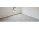 An empty bedroom with neutral carpeting, white walls, a window looking to the backyard at 711 Lily Blossom Path, Lawrenceville, GA 30045