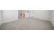 Spacious bonus room with plush neutral carpeting, bright natural light, and a view of the staircase at 711 Lily Blossom Path, Lawrenceville, GA 30045