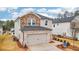 Charming two-story home with an attached garage, showcasing a blend of brick and siding at 711 Lily Blossom Path, Lawrenceville, GA 30045