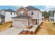 Two-story home featuring brick, stone, and siding, plus an attached two-car garage at 711 Lily Blossom Path, Lawrenceville, GA 30045