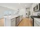 Bright kitchen featuring stainless steel appliances, a large island with quartz countertops, and wood flooring at 711 Lily Blossom Path, Lawrenceville, GA 30045