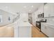 Open kitchen with white cabinetry, stainless steel appliances and a central island, seamlessly connecting to the living area at 711 Lily Blossom Path, Lawrenceville, GA 30045