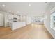 Open living space featuring wood floors, recessed lighting and a kitchen with white cabinetry at 711 Lily Blossom Path, Lawrenceville, GA 30045