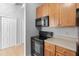 Modern kitchen with wood cabinets and black appliances at 32 Peachtree Nw St # 804, Atlanta, GA 30303