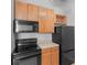 Modern kitchen with wood cabinets and black appliances at 32 Peachtree Nw St # 804, Atlanta, GA 30303