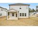 Rear exterior view with light gray siding, a covered patio, and a lawn at 602 Wallace Oak Ln, Lawrenceville, GA 30045