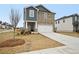 Two-story home with stone and blue siding, a two-car garage, and a tree in the front yard at 602 Wallace Oak Ln, Lawrenceville, GA 30045