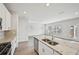 An open kitchen with granite countertops, stainless steel appliances, a sink in the island and a view of the living room at 602 Wallace Oak Ln, Lawrenceville, GA 30045