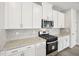 Modern kitchen features white cabinetry, granite countertops, stainless steel appliances, and mosaic tile backsplash at 602 Wallace Oak Ln, Lawrenceville, GA 30045