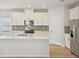Bright kitchen features white cabinets, stainless steel appliances, and a large center island at 1260 Firefly Field Trce Trce, Lawrenceville, GA 30045