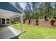 Well-manicured backyard featuring a covered patio, lush green grass, and privacy at 48 Easton Park Blvd, Dallas, GA 30157