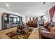 Living room with hardwood floors, leather furniture, and a large TV at 909 Teabiscuit Way, Mcdonough, GA 30253