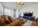 Relaxing sitting area with a brown leather couch and a ceiling fan at 909 Teabiscuit Way, Mcdonough, GA 30253