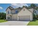 Two-story house with light brick exterior, three-car garage, and landscaped lawn at 211 Linford Dr, Locust Grove, GA 30248