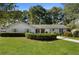 Ranch style home with white brick facade, manicured lawn, and mature trees at 1736 Ridge Valley Ct, Atlanta, GA 30327