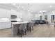 Open kitchen with white cabinets, gray island, stainless steel appliances, and hardwood floors at 2133 Kirkham Way, Kennesaw, GA 30152