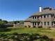 Large backyard with green lawn featuring a brick house with many windows under a blue sky at 331 Wages Rd, Auburn, GA 30011