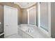 Soaking tub surrounded by windows and marble tiling at 331 Wages Rd, Auburn, GA 30011