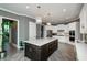 Bright kitchen featuring a dark island with a white countertop, stainless steel appliances, and decorative pendant lights at 331 Wages Rd, Auburn, GA 30011