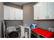Functional laundry room with modern washer and dryer, gray walls, and white cabinets for storage at 331 Wages Rd, Auburn, GA 30011