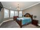 Main bedroom with an elegant chandelier, large windows and dark wood furniture at 331 Wages Rd, Auburn, GA 30011