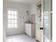 Bright bathroom with white shaker cabinets, beadboard, and penny tile floor at 9060 Selborne Ln, Chattahoochee Hills, GA 30268