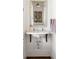 Small bathroom with a pedestal sink and antique mirror at 9060 Selborne Ln, Chattahoochee Hills, GA 30268