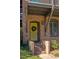 Brick front entrance with a yellow door, steps, and landscaping at 9060 Selborne Ln, Chattahoochee Hills, GA 30268