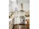 White kitchen with stainless steel appliances and wood island at 9060 Selborne Ln, Chattahoochee Hills, GA 30268