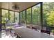 Large screened porch with a long wooden table and chairs at 9060 Selborne Ln, Chattahoochee Hills, GA 30268