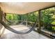 Relaxing screened porch with two hammocks, wood-like tile floor, and tranquil wooded views at 9060 Selborne Ln, Chattahoochee Hills, GA 30268