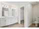 Bright bathroom featuring a double sink vanity, large mirror, and a walk-in closet at 4235 Holland Grove Rd, Lawrenceville, GA 30044
