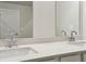 Bright bathroom featuring double sinks with quartz countertop and modern chrome faucets at 4235 Holland Grove Rd, Lawrenceville, GA 30044