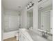 Bright bathroom featuring a double sink vanity, large mirror, and a bathtub with shower at 4235 Holland Grove Rd, Lawrenceville, GA 30044