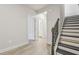 Hallway with staircase, light wood flooring, and open door to the half bath at 4235 Holland Grove Rd, Lawrenceville, GA 30044