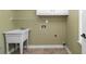 Bright laundry room with built-in cabinets and utility sink at 1685 Terrace Lake Dr, Lawrenceville, GA 30043