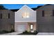 Two-story townhome with gray siding, brick accents, and a two-car garage at 4255 Holland Grove Rd, Lawrenceville, GA 30044